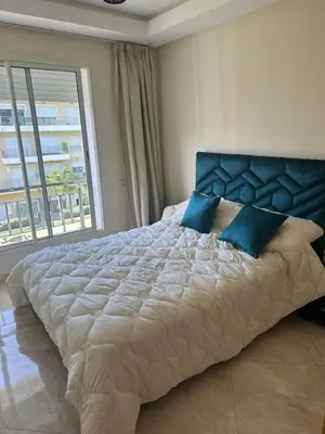 a large bed in a bedroom with a large window at Les jardins de bouznika in Bouznika