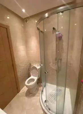 a bathroom with a toilet and a glass shower at Les jardins de bouznika in Bouznika