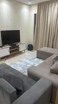 a living room with two beds and a flat screen tv at Les jardins de bouznika in Bouznika
