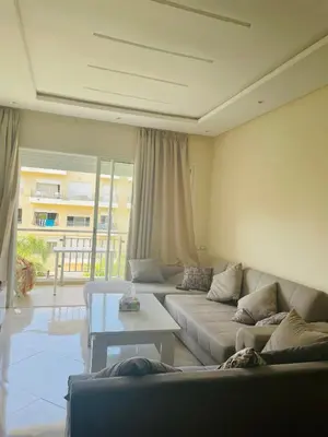 a living room with a couch and a table at Les jardins de bouznika in Bouznika