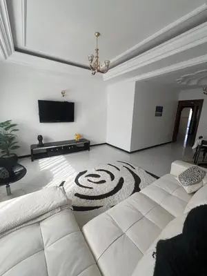 a living room with a couch and a flat screen tv at Spacieux appartement proche de la mer in Casablanca