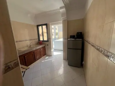 a kitchen with a refrigerator and a sink at Spacieux appartement proche de la mer in Casablanca