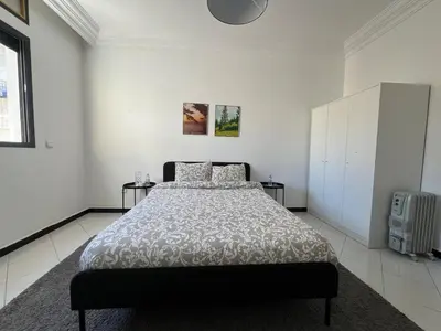 a white bedroom with a large bed in it at Spacieux appartement proche de la mer in Casablanca
