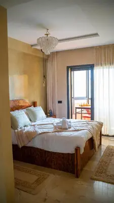 a bedroom with a large bed and a window at Nafhat al arz - Moroccan and refined in Mohammedia