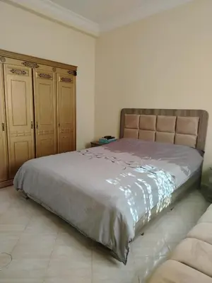 a bedroom with a large bed and two cabinets at Dar Isa in Sidi Rahal