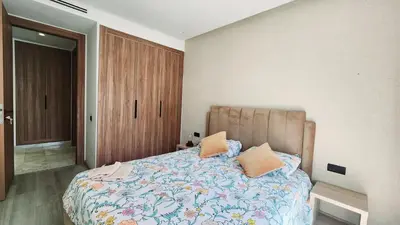 a bedroom with a bed with a floral bedspread at Studio Cosy les Princesses in Casablanca