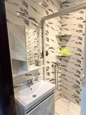 a white bathroom with a sink and a mirror at résidence Amina in Rabat