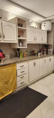 a kitchen with white cabinets and a counter top at appartement el Mansouria Sable d'or in O Ben Slimane