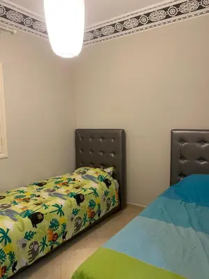 a bedroom with a bed with a comforter on it at Appartement location saisonnière Mohammedia in Mohammedia