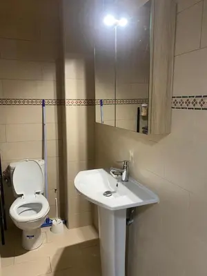 a bathroom with a toilet and a sink and a mirror at Appartement location saisonnière Mohammedia in Mohammedia