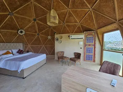 a bedroom in a yurt with a bed and chairs at Bougainvilla Guesthouse in Sidi Moussa Ben Ali