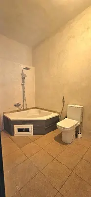 a bathroom with a bath tub and a toilet at Bougainvilla Guesthouse in Sidi Moussa Ben Ali