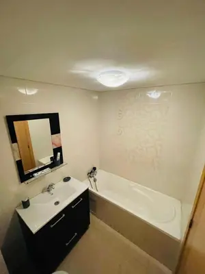 a bathroom with a sink and a bath tub and a mirror at Ola blanca 1 enjoy in Sidi Rahal