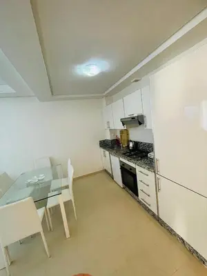 a kitchen with a table and a table and a dining room at Ola blanca 1 enjoy in Sidi Rahal