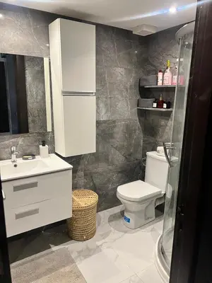 a bathroom with a white toilet and a sink at Appartament Melrose beach dar bouazza in Tamaris