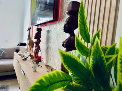 a table in a living room with a plant and a statue at Apartment in rabat agdal in Rabat