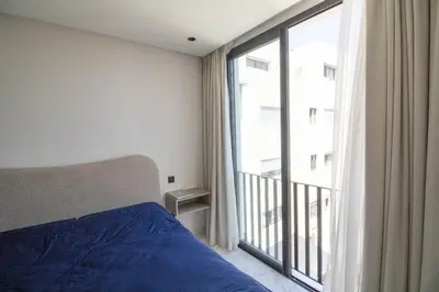 a bedroom with a bed and a large window at Appartement Ferme Bretonne - Confort & Premium in Casablanca