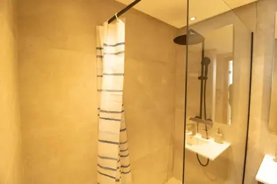 a bathroom with a shower with a shower curtain at Appartement Ferme Bretonne - Confort & Premium in Casablanca