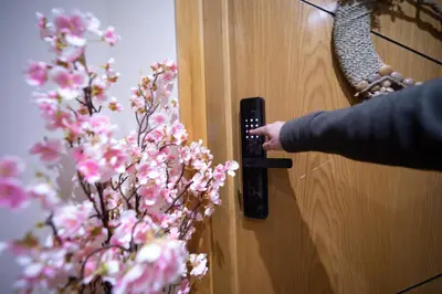 a person unlocking a wooden door with a plant at R106- Amazing & Colourful Apartment near High Speed Train Station in Casablanca