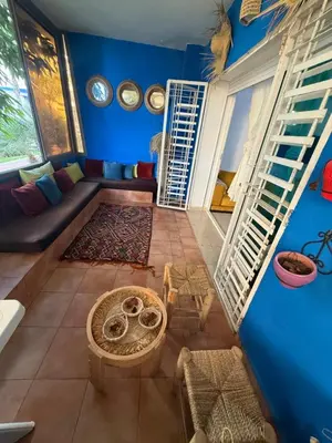 a living room with blue walls and a couch at Appartement moderne à louer à Mansouria résidence avec piscine in Mansouria
