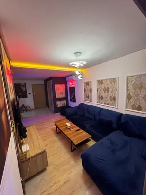 a living room with a blue couch and a table at Studio a maarif in Maarif