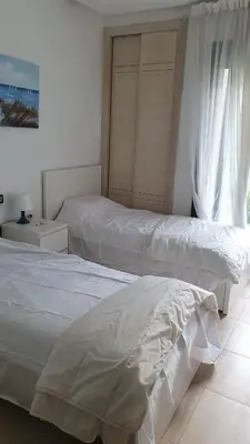 a bedroom with two beds and a window at Ground floor apartment - Residence Skhirat Beach 2 in Skhirat