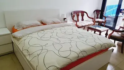 a bedroom with a bed and two chairs at Ground floor apartment - Residence Skhirat Beach 2 in Skhirat