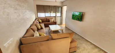 a living room with a couch and a table at Belle Appartent Vue Piscine A Malaga Beach A Mansouria in Mansouria