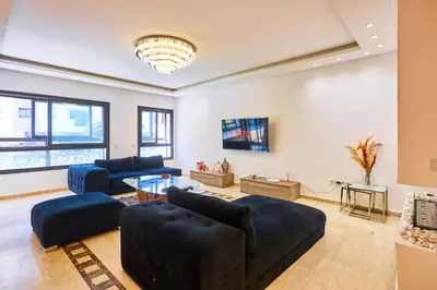 a living room with two blue couches and a tv at Casablanca 3 Bed Unit in Triangle Dor With Parking in Casablanca
