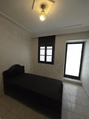 a bedroom with a black bed and two windows at Havre de paix en plein coeur de Casa in Casablanca