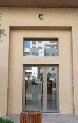 a building with a glass door with a sign on it at Charmante Deux Chambres et Salon Avec Jardin et Piscine à coté de plage in Casablanca