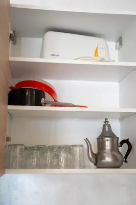 a kitchen shelf with a tea kettle and dishes at Charmante Deux Chambres et Salon Avec Jardin et Piscine à coté de plage in Casablanca