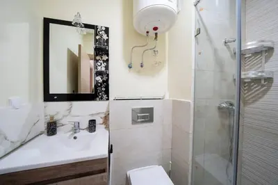 a bathroom with a toilet and a sink and a shower at Appartement 2 Chambres à Coté avec Grand Balcon, Piscine, Aire de Jeux pour Enfants et Jardin in Casablanca