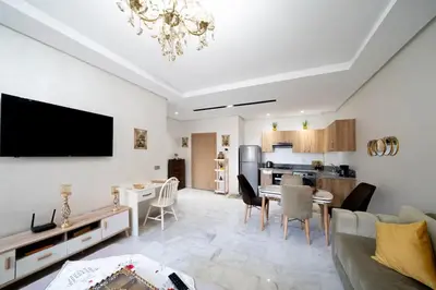a living room with a couch and a dining room at Studio Confortable avec Balcon, Piscine, Jardin et Aire de Jeux in Casablanca