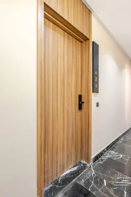 a wooden door in a hallway with a tile floor at VIVASTAY Casablanca - Cosy Maarif Arena 41 in Maarif