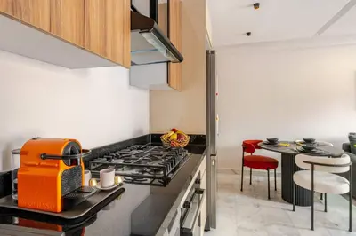 a kitchen with a stove top oven next to a table at VIVASTAY Casablanca - Cosy Maarif Arena 41 in Maarif