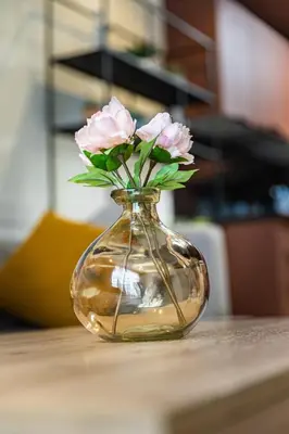 a glass vase with pink flowers in it on a table at Cosy Studio - Fitness access & Free Parking & Wifi Fiber in Casablanca