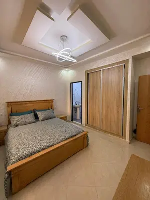 a bedroom with a bed and a ceiling fan at Comfortable and quiet apartment with Buzzinga in Bouznika