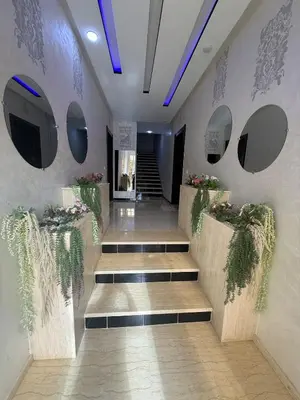 a lobby with stairs and plants on the wall at Comfortable and quiet apartment with Buzzinga in Bouznika