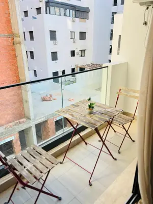 a table and chairs on a balcony with a view of a building at Rafina in Casablanca