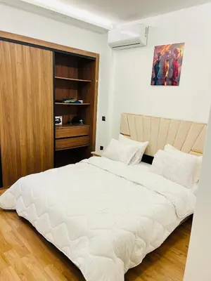 a bedroom with a large white bed and a wooden cabinet at Rafina in Casablanca