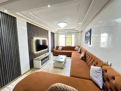 a living room with a large couch and a television at Comfortable, quiet and beach apartment in Skhirat
