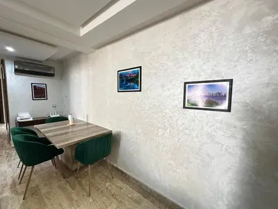 a dining room with a table and green chairs at Comfortable, quiet and beach apartment in Skhirat