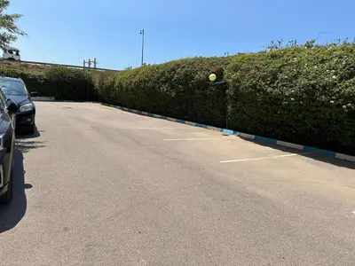 a car parked in a parking lot next to a hedge at Comfortable, quiet and beach apartment in Skhirat