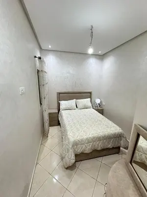 a small bedroom with a bed and a couch at Apartment 1 CH près de la plage in Oulad Akkou