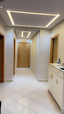 an office room with a hallway with white tile floors at Charming apartment in Mansoria in Mohammedia