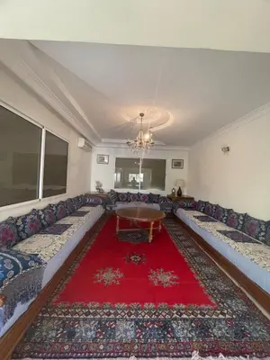 a living room with couches and a red rug at Villa à louer nouaceur 3 chambres in Nouaseur
