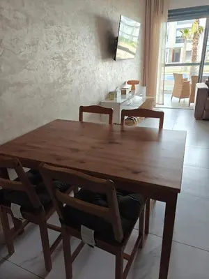 a wooden table and chairs in a living room at Casa Atlantica mit Meerblick und Poolparadies in Mansouria