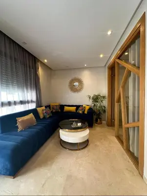 a living room with a blue couch and a table at Urban flat Bourgogne in Casablanca