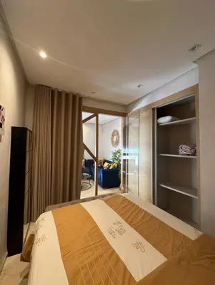 a bedroom with a large bed and a living room at Urban flat Bourgogne in Casablanca